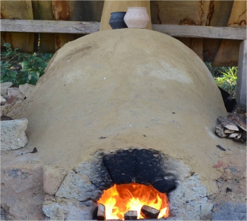 Een experimentele Frankische pottenbakkeroven brandt op het historische erf Erve Eme.