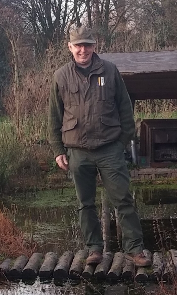 Robert Wimmers staat buiten naast een houten vlonder aan het water.